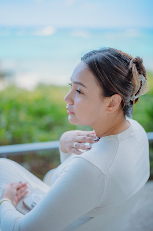 Woman in a White Blouse Sitting Outside 