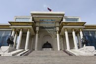 Front view of the historic Government Palace in Ulaanbaatar with Genghis Khan statue and columns.