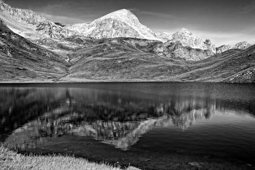 Black and White Photo of Mountains and a Lake 