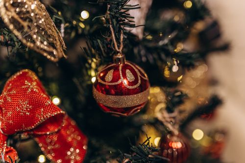 Free Close-up of a beautifully decorated Christmas tree with a red bauble and warm bokeh lights. Stock Photo
