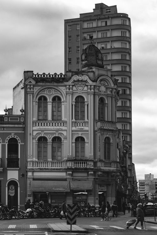 Free Black and white photo of an elegant historical building in a bustling urban street. Stock Photo