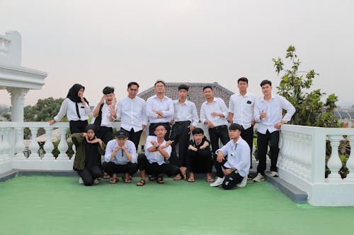 A Group of Young Elegant Men and Women Standing in a Group and Smiling 