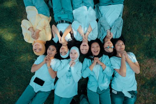 Free Seven young women lying on grass, smiling and having fun together outdoors. Stock Photo
