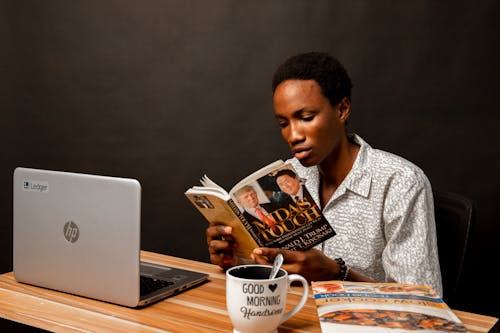 Young Man Sitting and Reading a Book 