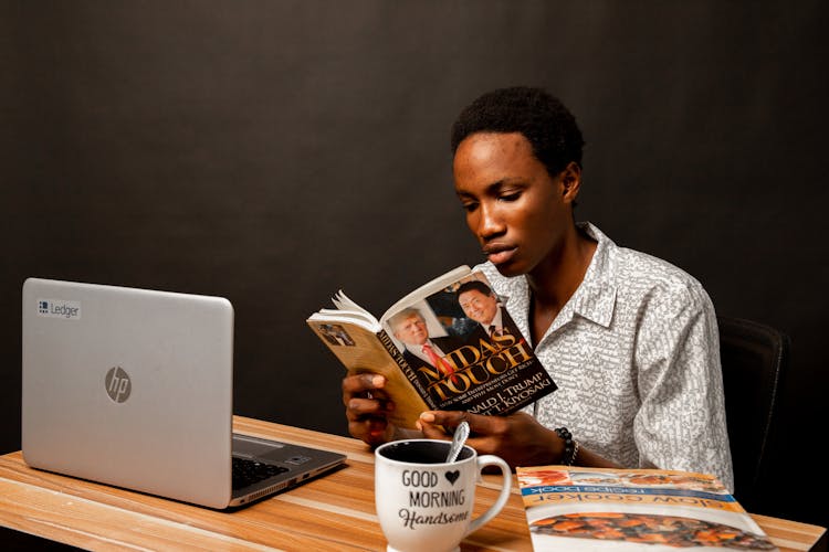 Young Man Sitting And Reading A Book 