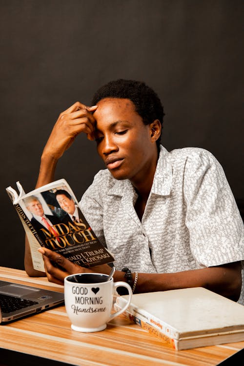 Young Man Sitting and Reading a Book 