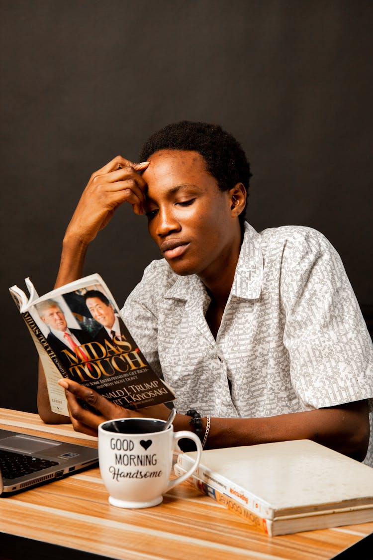 Young Man Sitting And Reading A Book 