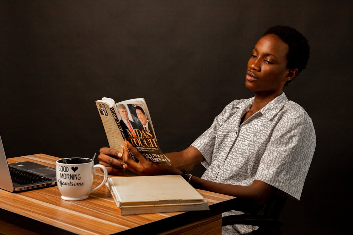 Young Man Sitting and Reading a Book 