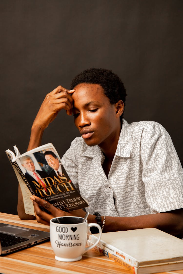 Young Man Sitting And Reading A Book 