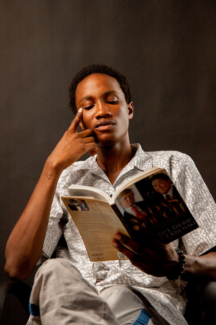 Young Man Sitting And Reading A Book 