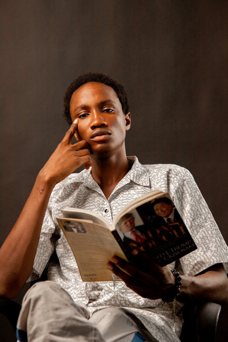 Young Man Sitting And Reading A Book 