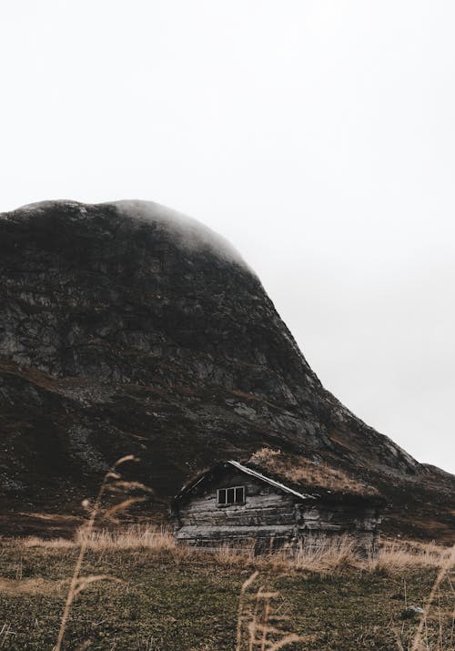 Free Old Wooden Cottage at the Foot of a Mountain  Stock Photo