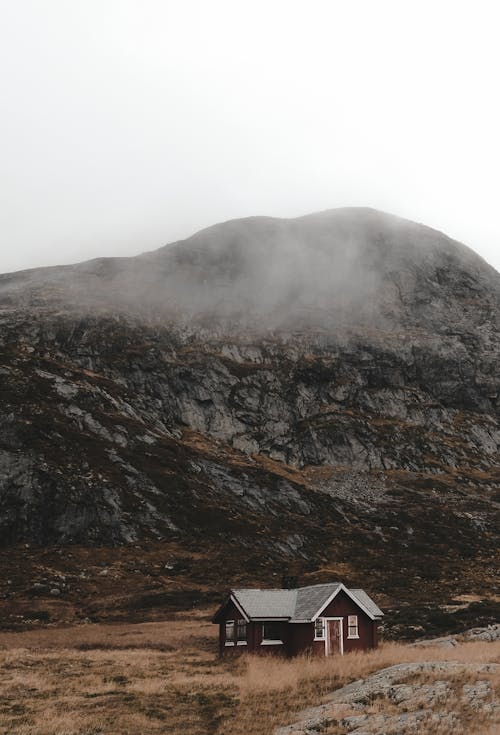 A small cabin in the mountains with a foggy sky