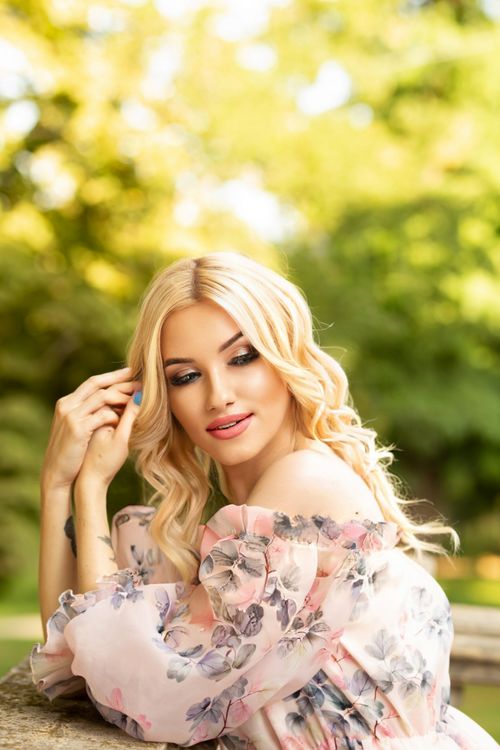 Free Blonde woman in floral dress enjoying a sunny day in a park in Ankara, Turkey. Stock Photo