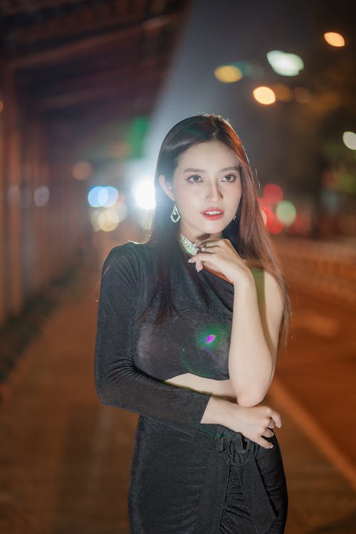 Woman Wearing Black Dress on a Street at Night 