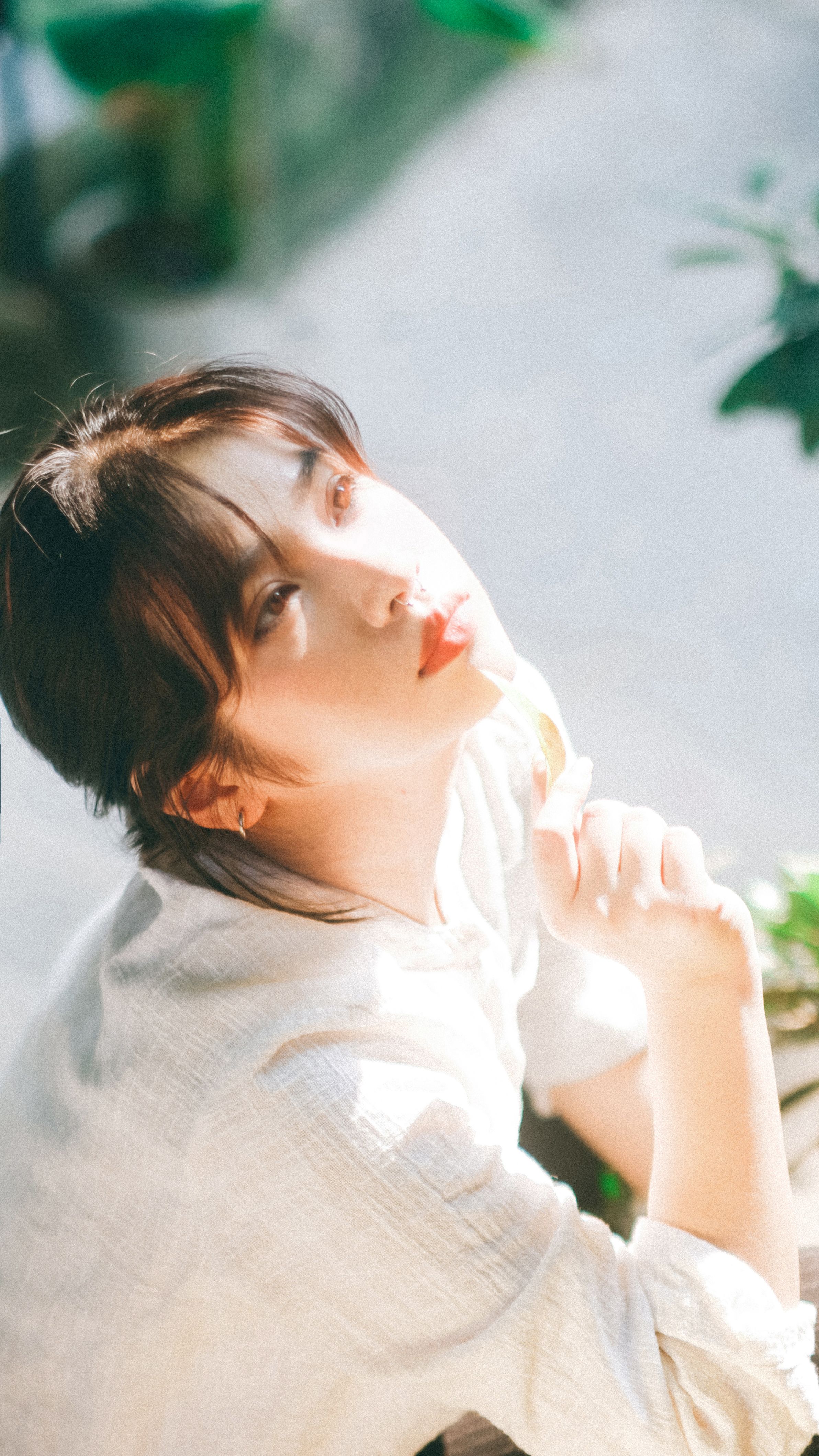 Young woman in sunlight outdoors, exuding calm and relaxation.