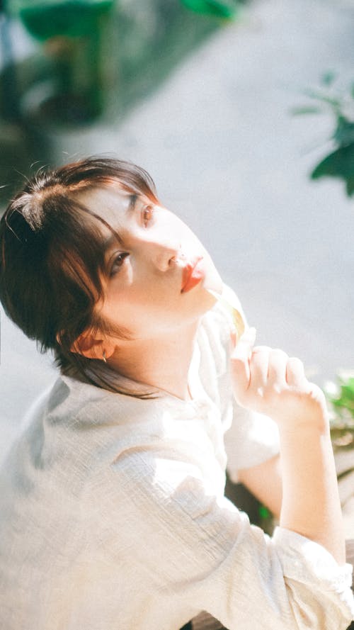 Young Woman Sitting Outside in Sunlight