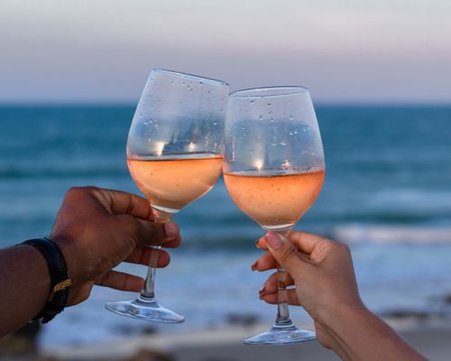 Free Couple toasts with rose wine by the seaside in Aquiraz, Brasil. Stock Photo