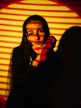 A dramatic portrait of a woman with creative lighting and red shadows, exuding elegance and intrigue.