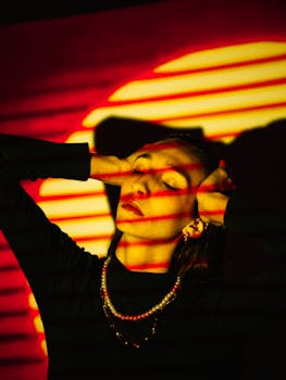 A captivating portrait of a woman with dramatic red and yellow lighting effects, embodying modern fashion artistry.