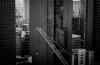 一张引人注目的黑白图像，展现了城市的摩天大楼和塔式起重机