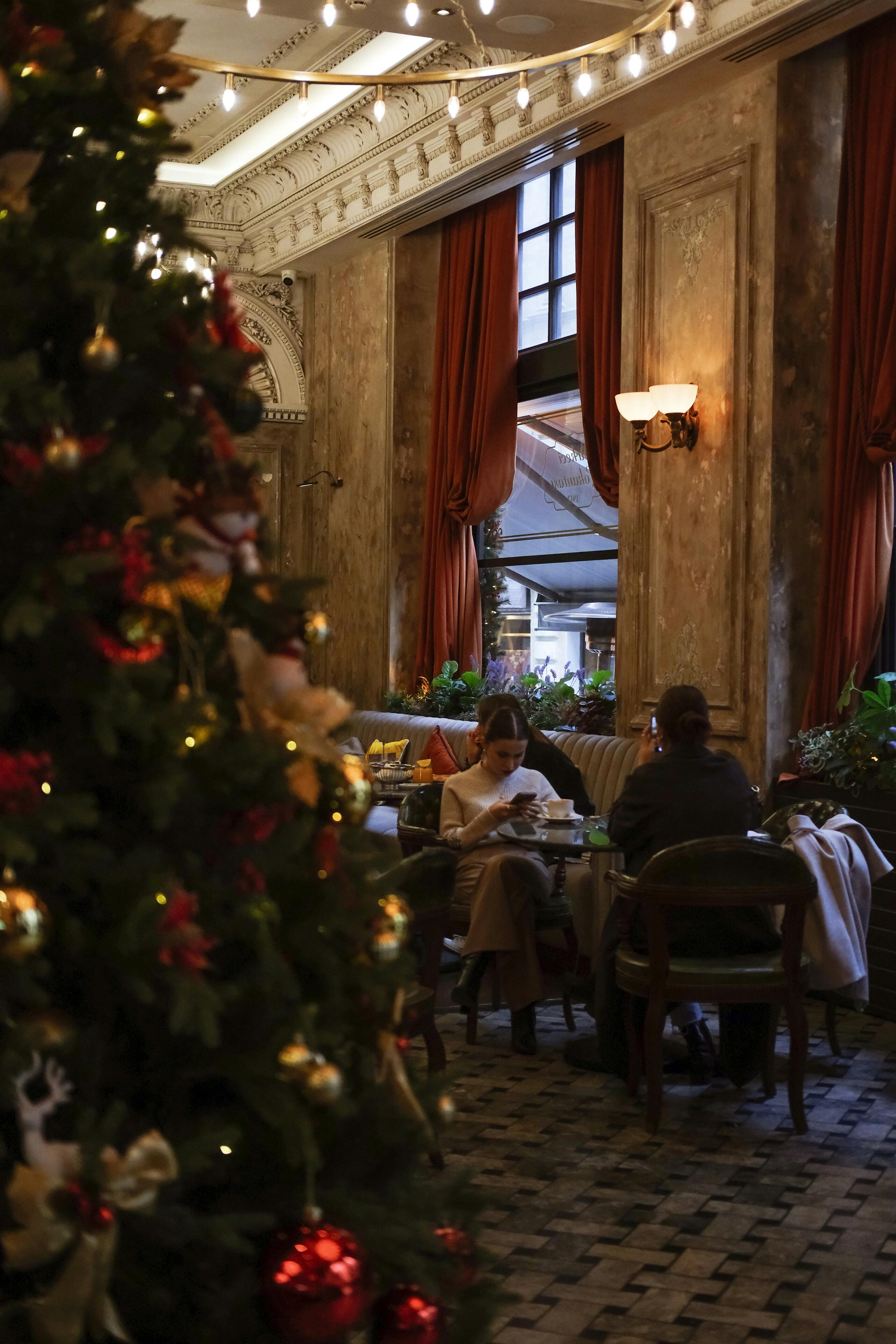 a christmas tree in a restaurant with people sitting at tables