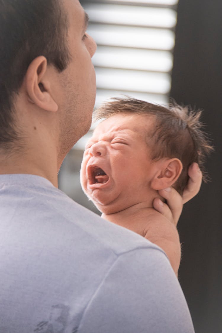 Father Holding Crying Baby