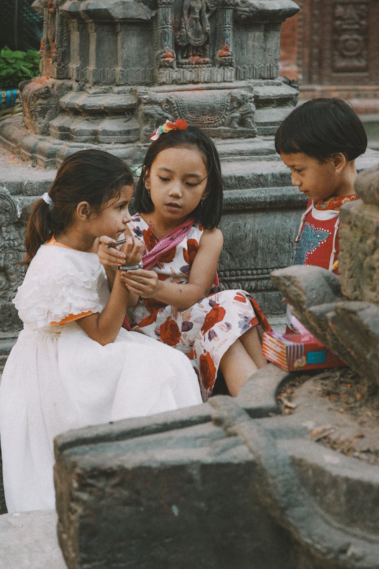 Girls In Dresses Sitting Together