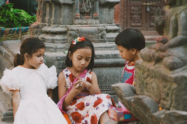 Girls In Dresses Sitting Together