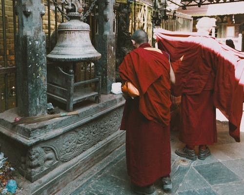 Buddhist Monks Standing near Bell