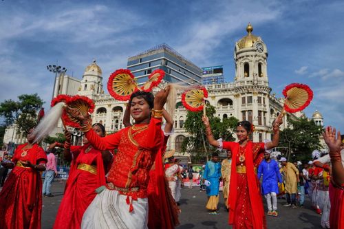 Free Traditional dancers in vibrant attire celebrate Indian culture in a Kolkata street parade. Stock Photo