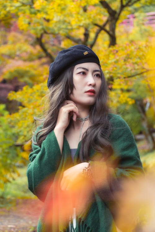 Young Woman in a Black Beret and Green Scarf Walking in the Park