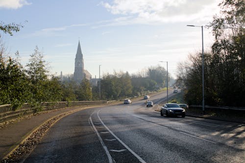Cars on an Asphalt Road with a Church in the Background