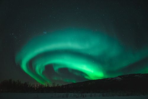 Free Captivating view of the glowing aurora borealis in Norway's night sky, showcasing vibrant green hues. Stock Photo