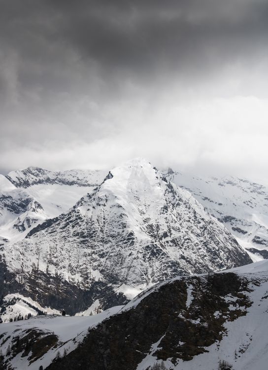 A snowy mountain with a cloudy sky above it · Free Stock Photo