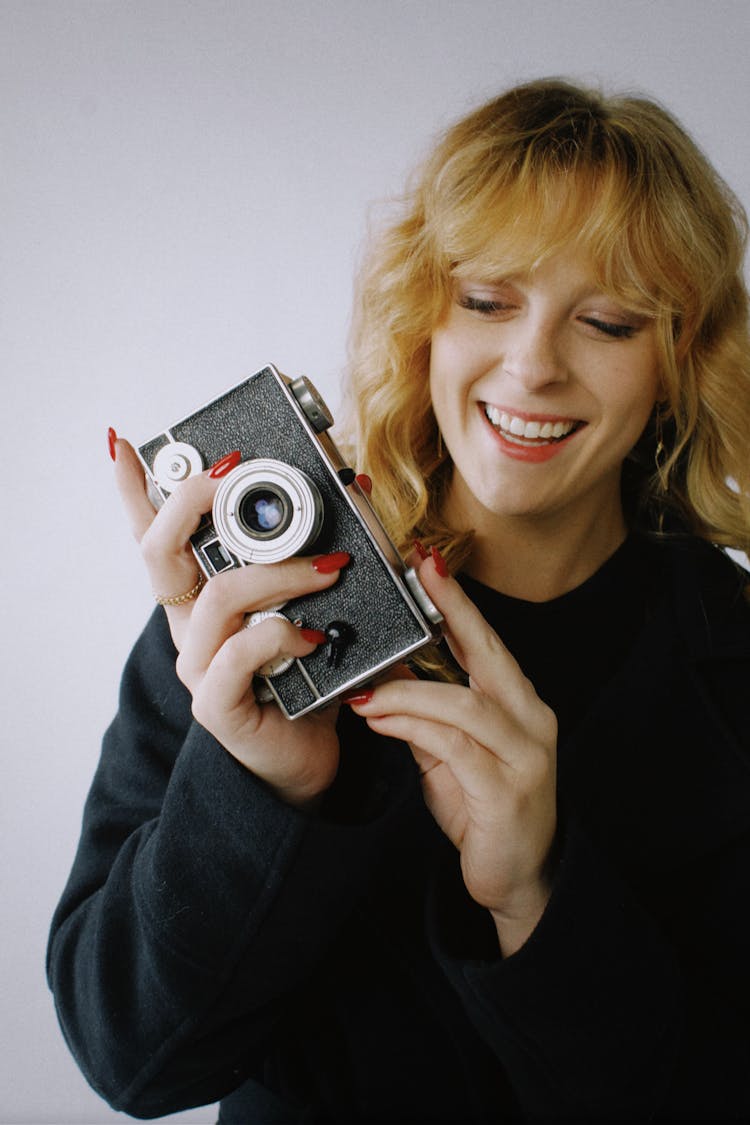 Smiling Woman Holding An Old Type Analog Camera