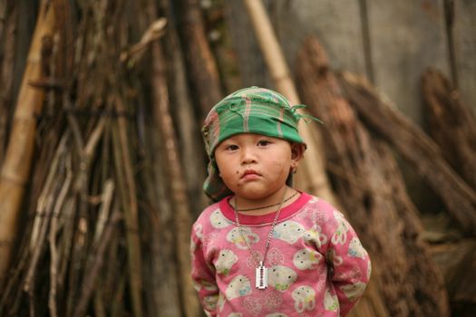 Little Child with Dirty Face Next to a Pile of Brushwood