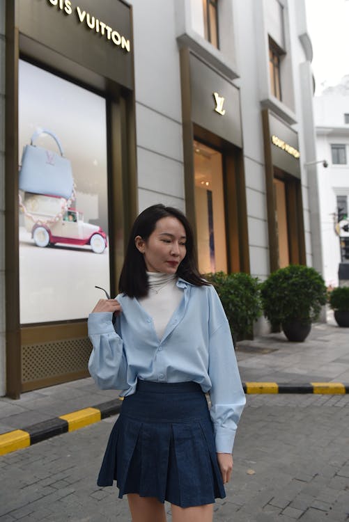 Portrait of a Female Model Wearing a Shirt and a Skirt Standing on a Sidewalk