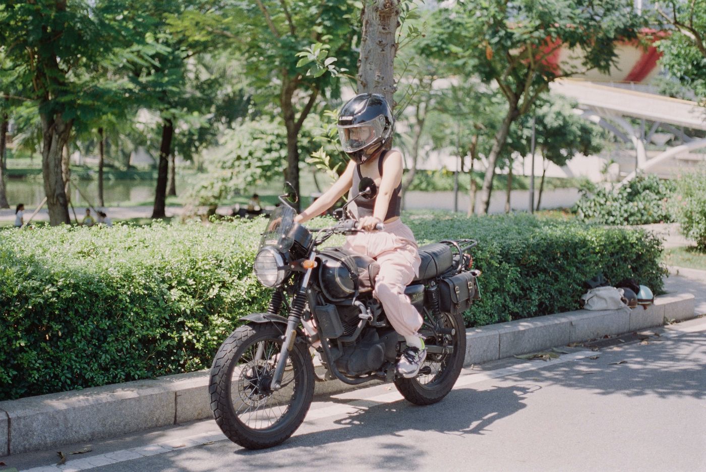 Mãe motociclista usando capacete em moto urbana com foco em segurança e conforto