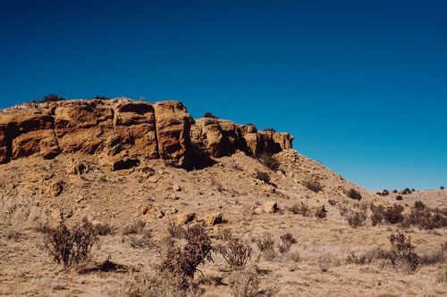 Free High-resolution image of rugged desert terrain with rock formations and clear blue sky. Stock Photo