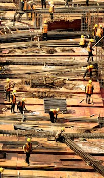 Workers in safety gear actively working on a large construction site.