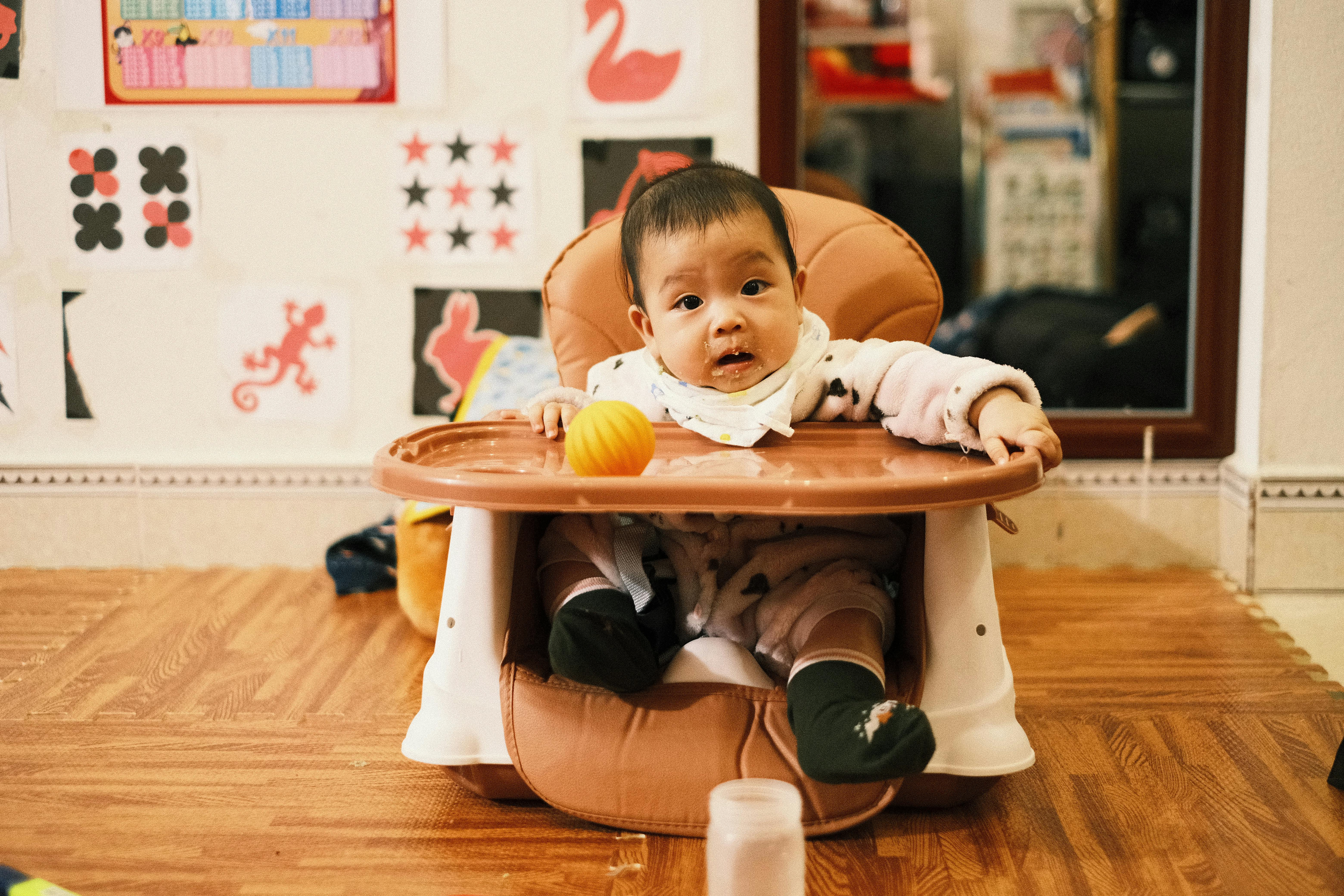 Baby Sitting on Baby Seat on Floor · Free Stock Photo