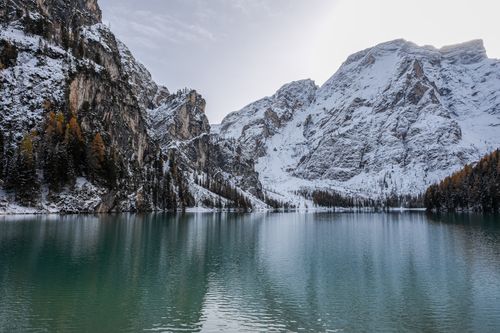 Free A serene snow-covered mountain landscape with a tranquil lake, showcasing the beauty of winter. Stock Photo