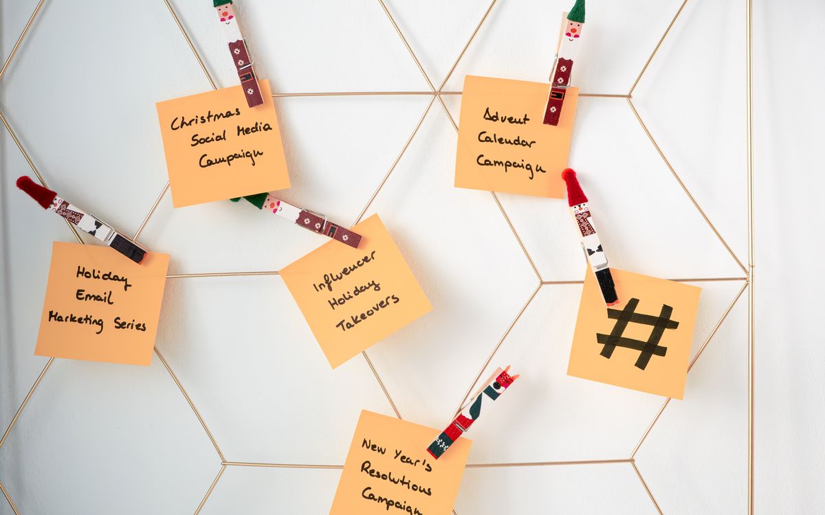 Sticky notes with holiday marketing ideas clipped to a wall grid.