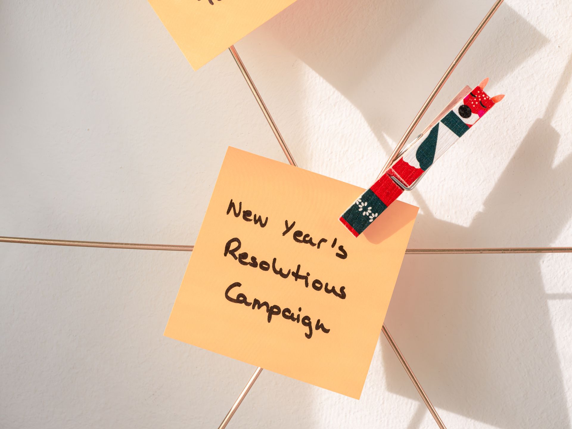 Bright sticky note with 'New Year's Resolutions Campaign', ideal for goal setting visuals.