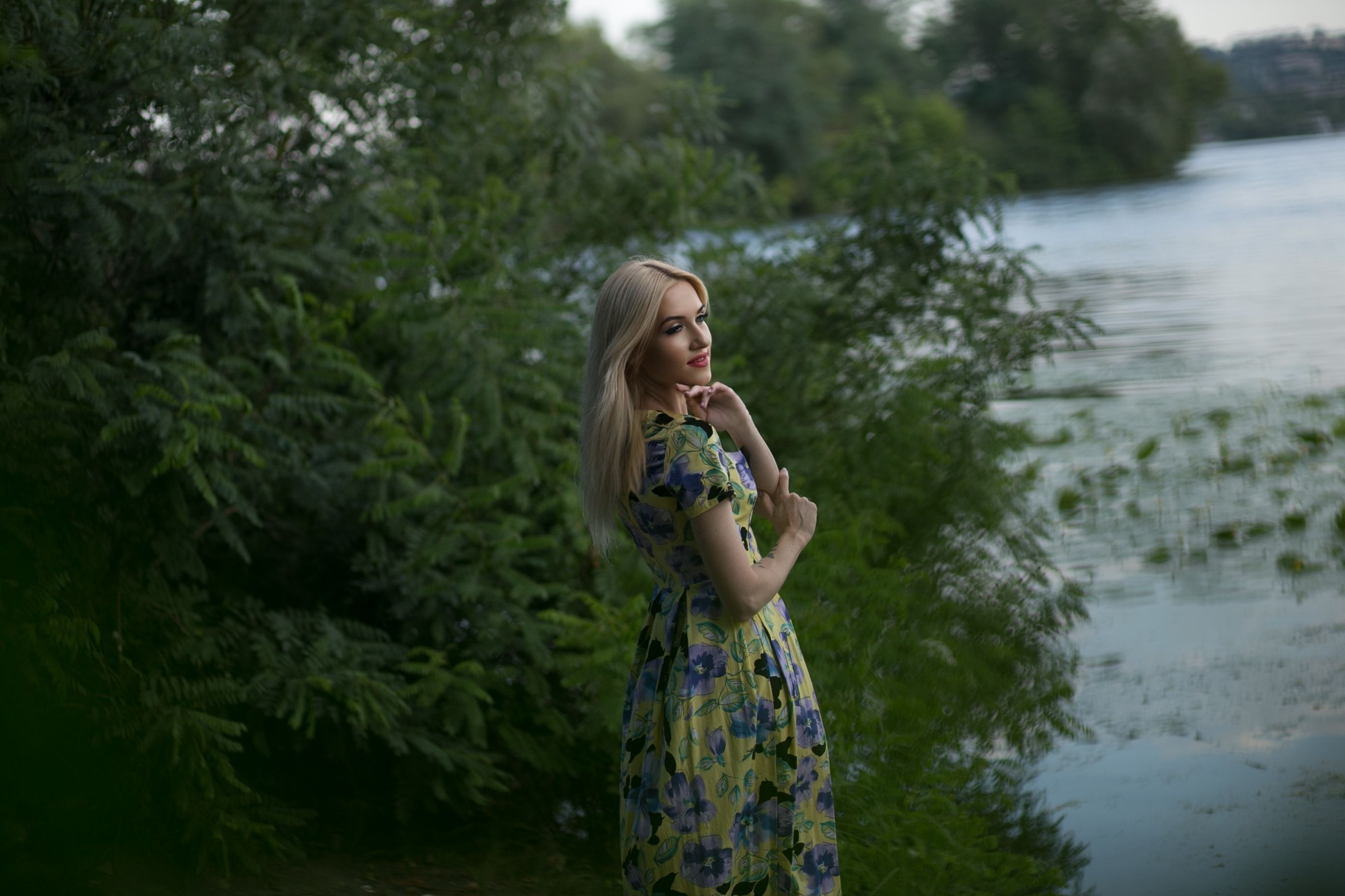 A woman in a floral dress standing near a river · Free Stock Photo
