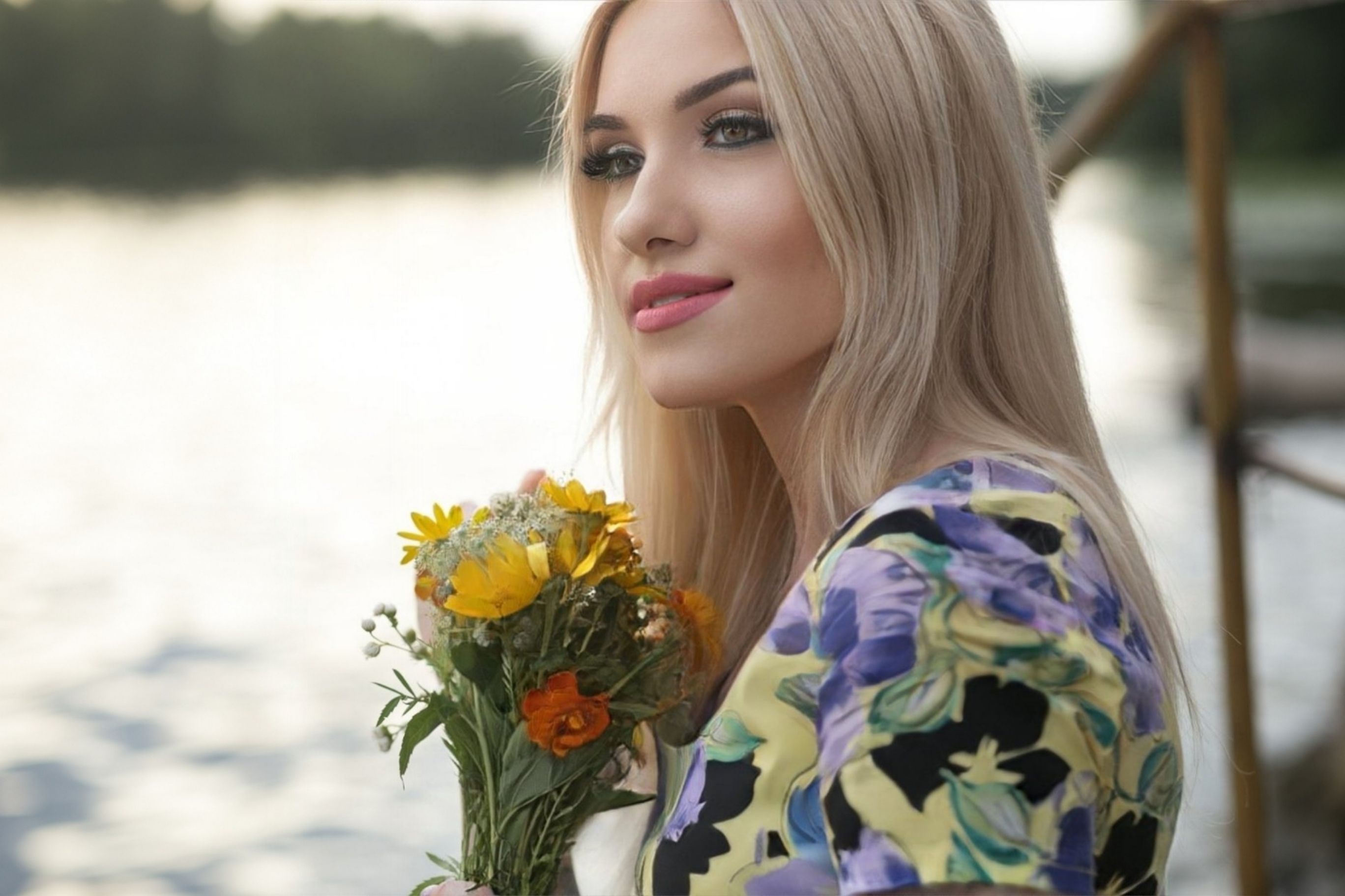A beautiful woman with a bouquet, standing by a river in Gdańsk, Poland.