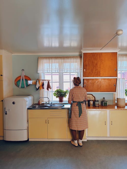 Back View of a Woman Standing in a Vintage Kitchen 