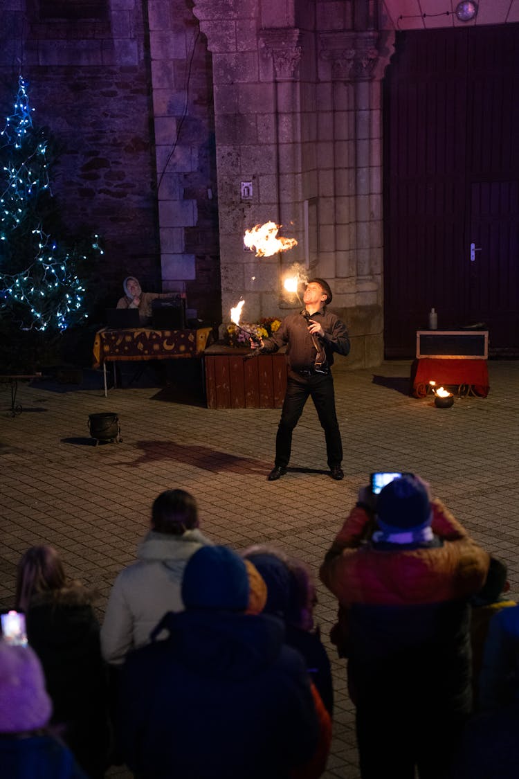 Fire Juggler Performing In Front Of Audience In City