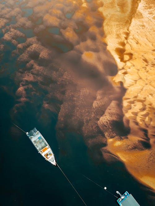 Aerial View of Boats Floating by a Sandy Shore